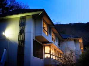 箱根Hot Spring Inn Hakone Suisen的白色房子,晚上设有阳台