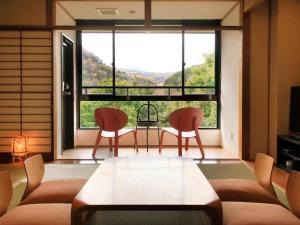 箱根Hot Spring Inn Hakone Suisen的客厅设有两把椅子、一张桌子和大窗户