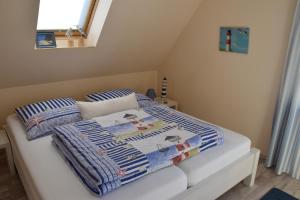 Gutglück"Ostseefische"的一张带蓝色和白色毯子的床和窗户