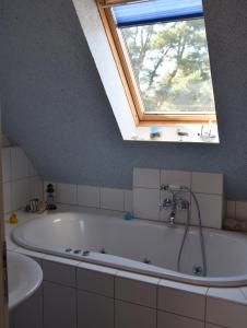 Gutglück"Ostseefische"的带浴缸的浴室和窗户