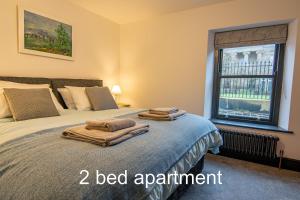 麦克尔斯菲尔德Market Square Grade II Listed Apartment的一间卧室配有一张床,上面有两条毛巾