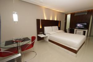 纳塔尔齐拉德雅丁姆拉鲁汽车旅馆（仅成人）的一间卧室配有一张床、一张桌子和一台电视