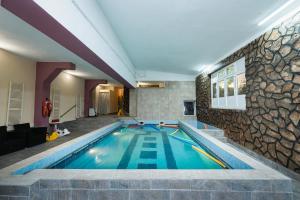 乔阿久拜AIDA Hotel spa & tratament的一座石墙房子内的游泳池