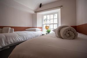 阿尼克The Bottles Lodge的一间卧室设有两张床和窗户。