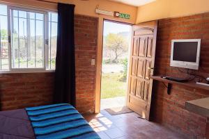 圣罗莎卡拉穆奇塔县Posada Tinktinkie的一间房间,设有门、电视和带窗户的门