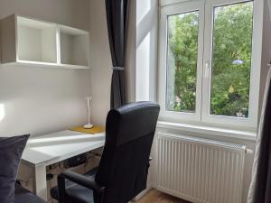 维也纳ClearVueHome - Green Studio 10min to Vienna Center的客房设有书桌、椅子和窗户。