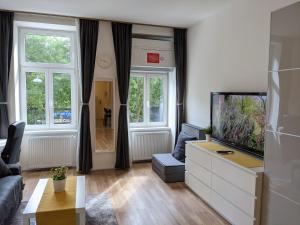 维也纳ClearVueHome - Green Studio 10min to Vienna Center的带沙发和电视的客厅