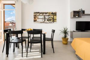维罗纳Civico40 Luminoso appartamento con balconi e garage privato的一间配备有黑色椅子和电视的用餐室