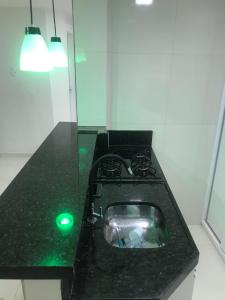 福塔莱萨Green Flat Fortaleza的厨房里设有黑色的台面,上面有绿灯