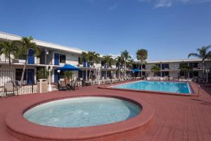圣彼得堡Days Inn by Wyndham St. Petersburg / Tampa Bay Area的一个带椅子的大型游泳池,一个度假村