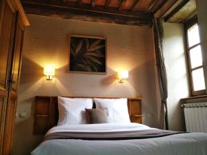瓦勒罗盖Auberge Cevenole的卧室配有一张带两盏灯的墙壁床。