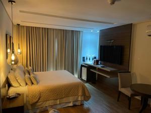 大坎普莫哈维酒店的酒店客房配有一张床、一张书桌和一台电视。