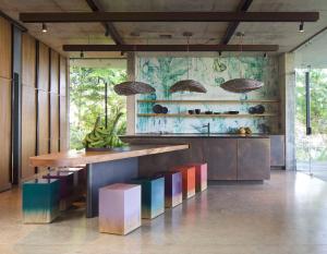 乌维塔Art Villas Costa Rica的厨房配有带五颜六色椅子的木台