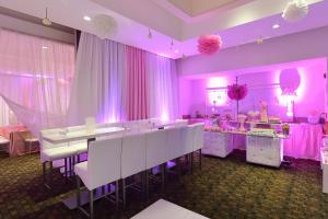 切图马尔切图马尔嘉年华酒店的用餐室配有白色的桌子和粉红色的窗帘