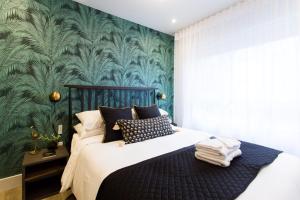 蒙特利尔Blue Tropics Studio in Little Italy with kitchen by Den Stays的一间卧室配有一张带绿色墙壁的床