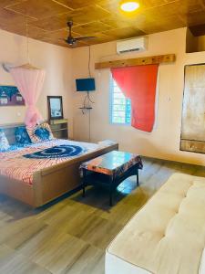 SanyangJungle Beach Resort的一间卧室配有一张床、一张桌子和一张沙发