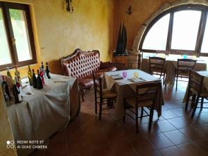 AlbeAntico Borgo di Albe的餐厅配有2张桌子和椅子,并提供葡萄酒瓶