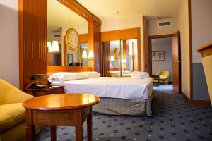 洛格罗尼奥Hotel los Bracos的酒店客房设有两张床和一张桌子。