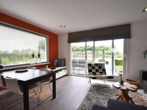 NigtevechtRiverside holiday home near Amsterdam的客厅配有桌椅和大窗户