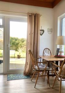 BallygalleyBallygally Seaview and Garden Hideaway的一间带桌椅和窗户的用餐室