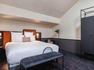 波尔多Mercure Bordeaux Centre Gare Atlantic的酒店客房带一张大床和一把椅子