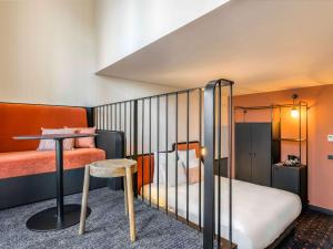 波尔多Mercure Bordeaux Centre Gare Atlantic的小房间设有一张床和一张桌子