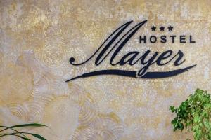 维斯普雷姆Hostel Mayer Superior Veszprém的墙上摇摆着的旅馆标志