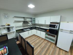 恩卡纳西翁Departamento todo 1 piso en Encarnación的厨房配有白色橱柜和白色冰箱。