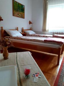 圣格奥尔基PENSIUNEA BORDÁS PANZIÓ的一间卧室配有两张床和一张桌子,桌子上配有四柱床。