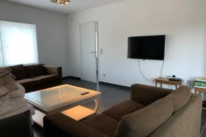 KruisemDuplex Appartement Nokeredorp - Vlaamse Ardennen的带沙发和咖啡桌的客厅