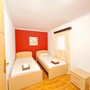 加瓦洛霍里翁Villa Nikolas的配有红色墙壁的小客房内的两张床