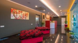 马六甲Riverfront Boutique Hotel的大堂设有两个红色凳子,墙上挂着一幅画