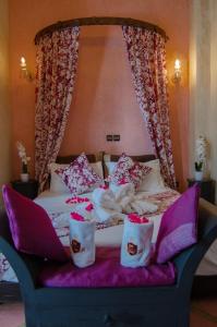 马拉喀什Riad L'Orchidée Suites & Spa的一张有红色玫瑰花天篷的床