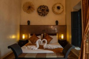 马拉喀什Riad L'Orchidée Suites & Spa的一间卧室配有一张带两个天鹅的床