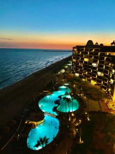 佩尼亚斯科港Sonoran Sea Resort Oceanfront PENTHOUSE的享有酒店和海滩的夜间景色