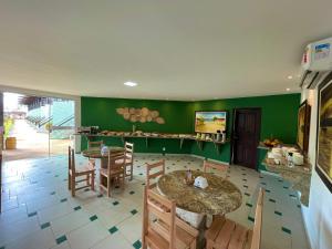 塞古罗港MUTA PRAIA HOTEL的用餐室设有两张桌子和绿色的墙壁
