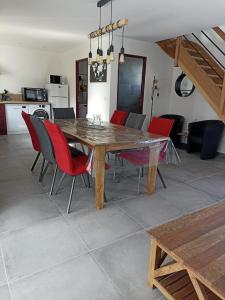 欧丹冈Le Repos du Randonneur的一间带木桌和红色椅子的用餐室
