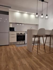 普拉加德阿罗somtresapartament的厨房配有白色橱柜和桌椅