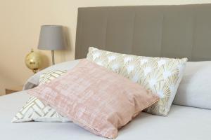 费拉拉Interno Estense 753的一张带粉红色枕头和枕头的床