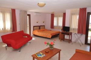 斯卡拉马里昂Elia Studios的客厅配有床和红色沙发