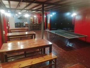 门多萨Katana Capsule Hostel的一间设有两张桌子和一张乒乓球桌的房间