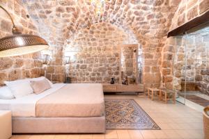 阿卡Zidan Sarai的一间卧室设有一张床和石墙