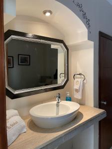 萨卡特卡斯Hotel Mina Vetagrande的一间带水槽和大镜子的浴室