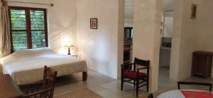 蓬蒂切里Isai Ambalam guest house的卧室配有一张床和一张桌子及椅子