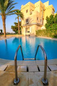 法尤姆Tache Boutique Hotel Fayoum的一座游泳池,其建筑背景为: