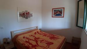莱乌卡La Casetta di Francesca的一间卧室配有一张带红色毯子的床
