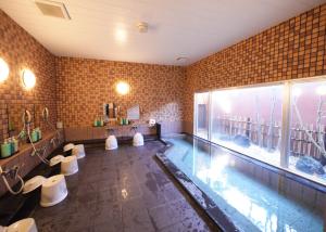 御前崎市御前崎鲁特因酒店的一个带卫生间和水族馆的浴室内的游泳池