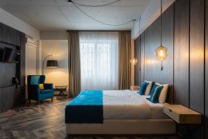 基希讷乌Tulip Residence & Spa Hotel的酒店客房,配有一张床和一张蓝色椅子