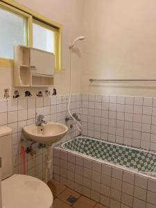 苗栗市官妈民宿的一间带水槽、浴缸和卫生间的浴室