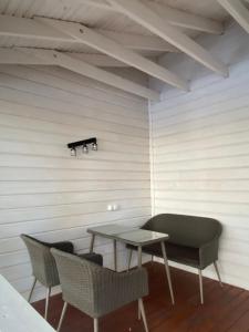 Glubokaya BalkaBalka Eco Club的白色墙壁的房间里摆放着桌椅